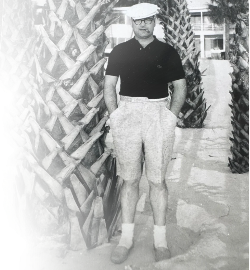 Mack Flowers Sr. in a cap and short sleeves, standing outside
