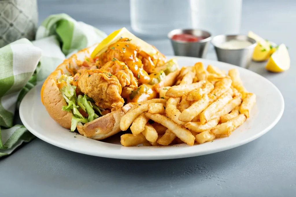 A fried oyster po'boy on a split roll with fries